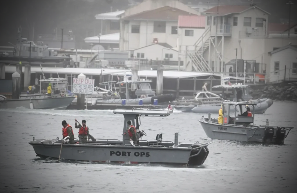 (In the background) Peraton boat operators run 11m RHIB engines to shield mammal pens from hazardous waste. Credit: Newslooks.com