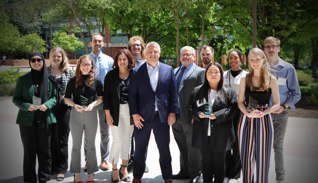    Peraton Chief Communications and Engagement Officer, Matt McQueen, standing with George Mason Honors College students who were awarded the Peraton Scholarship in National Security in 2024. Photo credit: George Mason University.